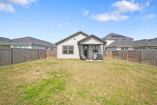 rear view of property with a lawn, outdoor lounge area, and a fenced backyard