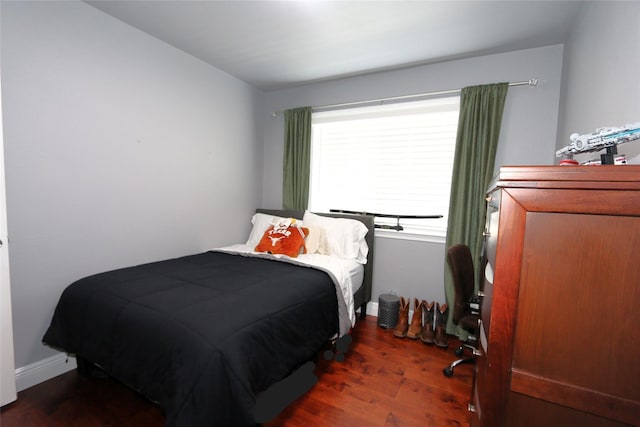 bedroom with baseboards and wood finished floors