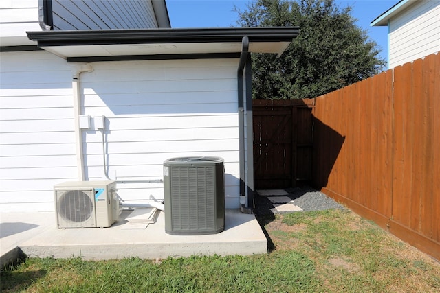 details featuring central air condition unit, ac unit, and fence