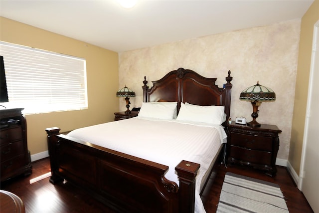 bedroom with dark wood finished floors and baseboards