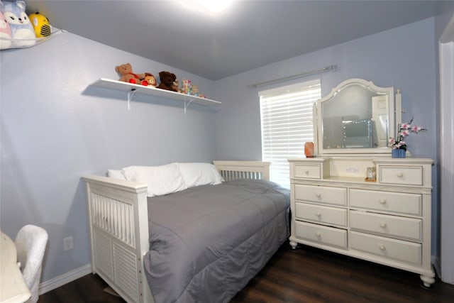 bedroom with dark wood-type flooring and baseboards