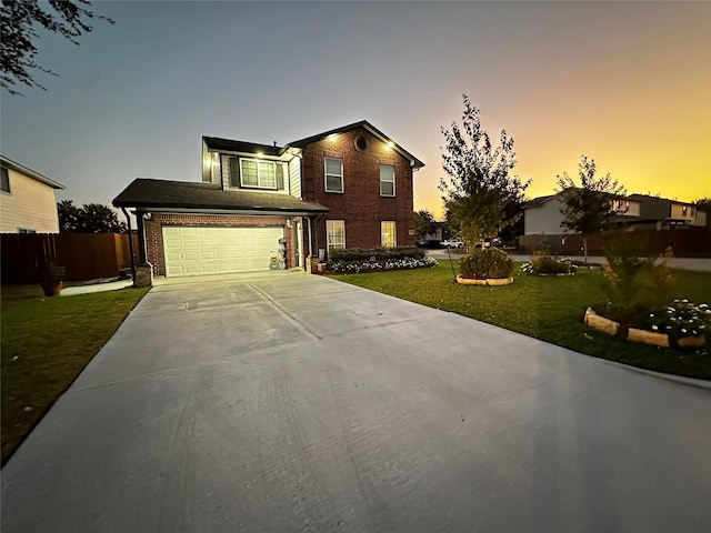 traditional home featuring a garage, brick siding, fence, driveway, and a front yard