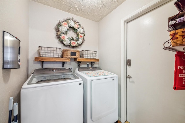 laundry room featuring laundry area, washing machine and dryer, and a textured ceiling