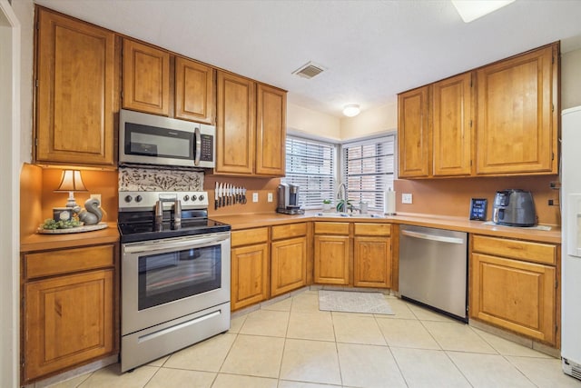 kitchen with visible vents, appliances with stainless steel finishes, light countertops, and a sink