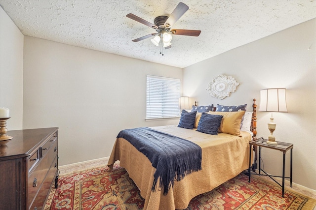 bedroom with a textured ceiling, a ceiling fan, and baseboards