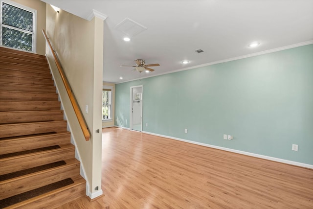 interior space featuring light wood finished floors, stairs, visible vents, and ornamental molding