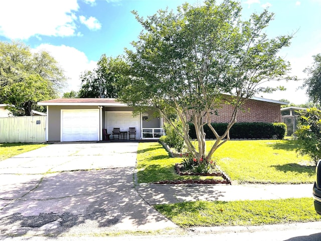 view of front facade featuring an attached garage, concrete driveway, a front yard, and fence