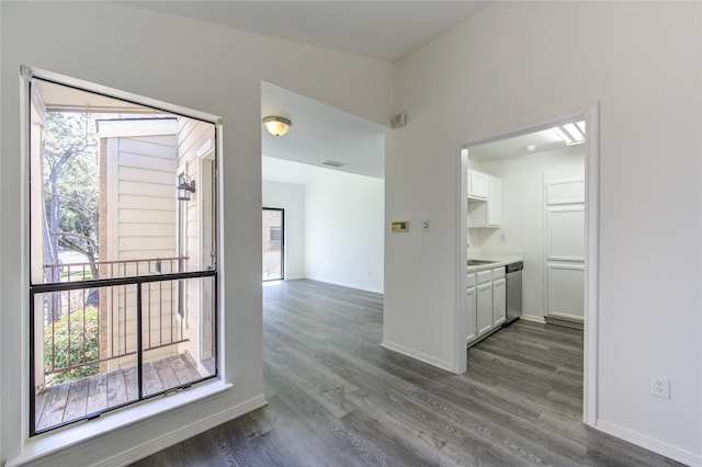 interior space with dark wood-type flooring, visible vents, plenty of natural light, and baseboards