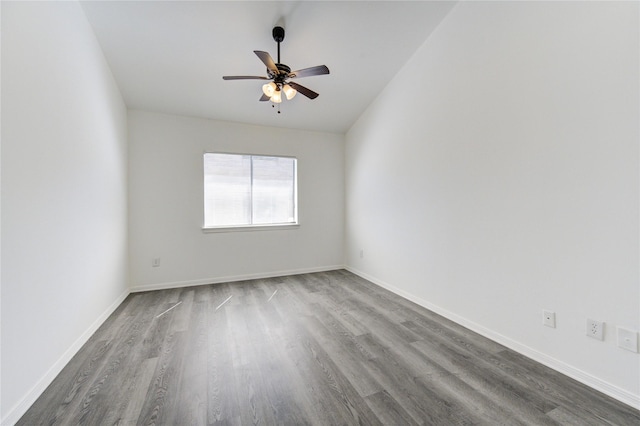 empty room featuring ceiling fan, baseboards, and dark wood-type flooring