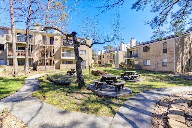 view of home's community featuring a residential view, a yard, and a fire pit