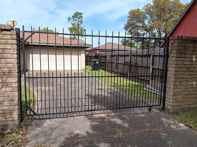 view of gate featuring fence and a yard