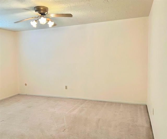 empty room with a ceiling fan, light carpet, and a textured ceiling