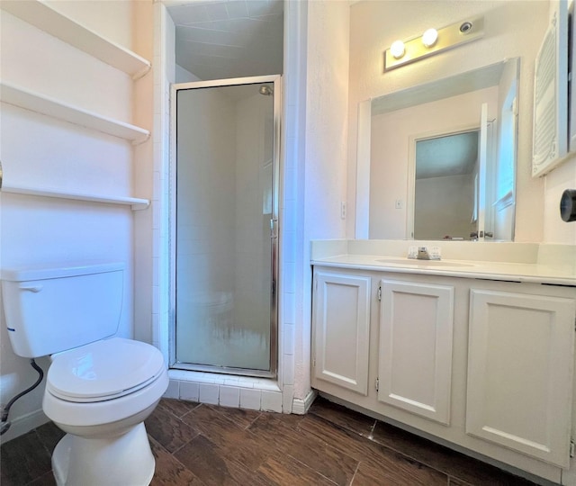 bathroom featuring toilet, a stall shower, wood tiled floor, and vanity