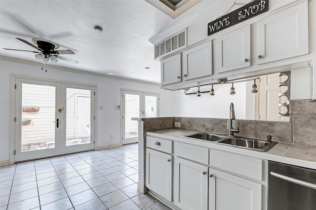 kitchen with french doors, white cabinetry, a sink, and stainless steel dishwasher