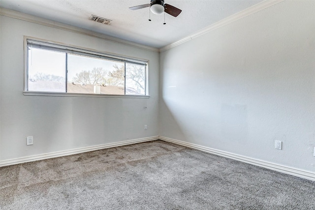 carpeted spare room featuring visible vents, a ceiling fan, and ornamental molding