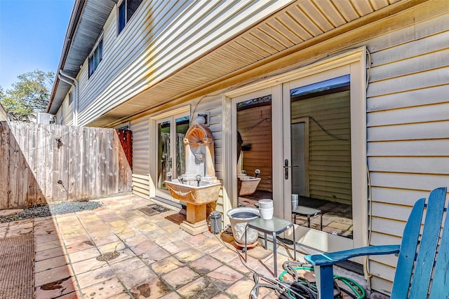 view of patio featuring french doors and fence