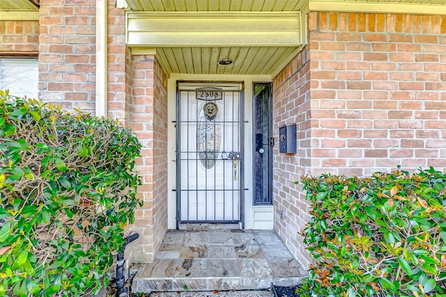 doorway to property featuring brick siding