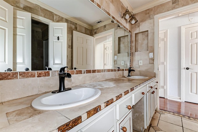 bathroom featuring ornamental molding, tile patterned flooring, a sink, and double vanity