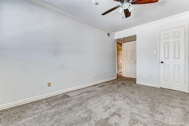 unfurnished bedroom with visible vents, ornamental molding, carpet flooring, ceiling fan, and baseboards