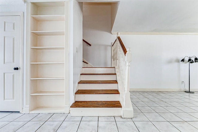 stairs featuring built in shelves and tile patterned floors