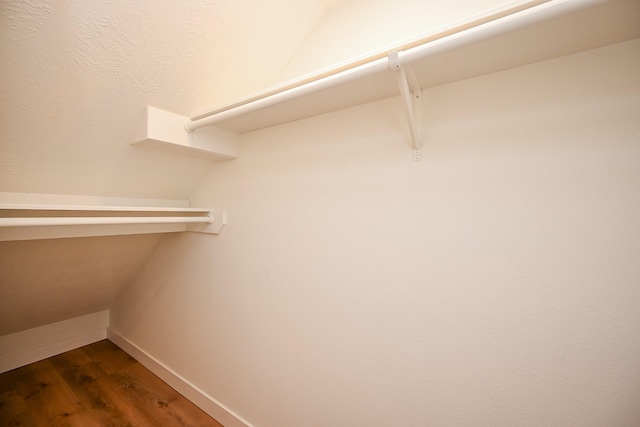 spacious closet with dark wood-style flooring