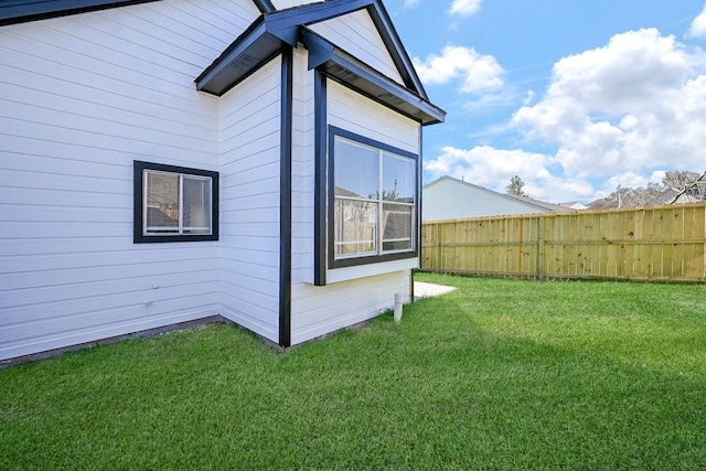 view of side of property featuring a yard and fence