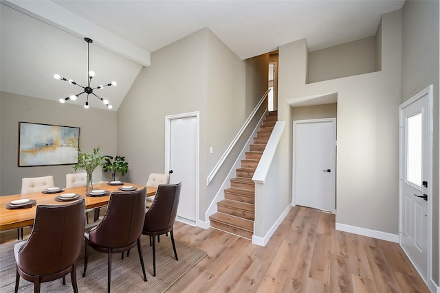 dining area with beam ceiling, stairway, a chandelier, light wood-type flooring, and baseboards