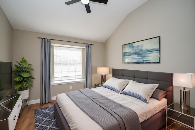 bedroom featuring a ceiling fan, lofted ceiling, baseboards, and wood finished floors