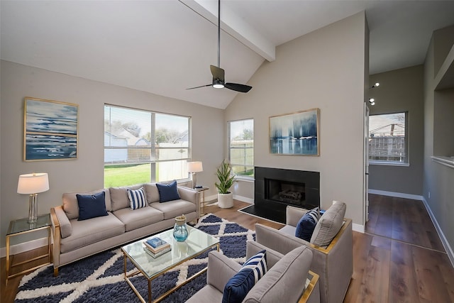 living room featuring beam ceiling, baseboards, a tiled fireplace, and wood finished floors