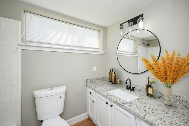 full bathroom featuring toilet, vanity, and baseboards