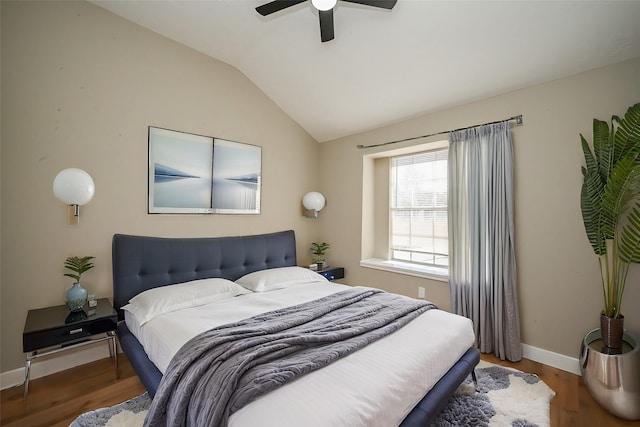 bedroom featuring a ceiling fan, baseboards, vaulted ceiling, and wood finished floors