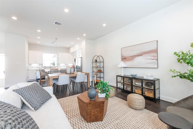 living room featuring dark wood-type flooring, recessed lighting, visible vents, and baseboards