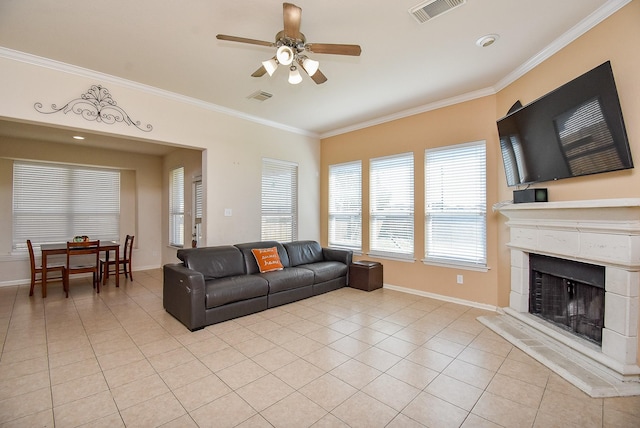 living area featuring a fireplace with raised hearth, ornamental molding, light tile patterned flooring, and visible vents