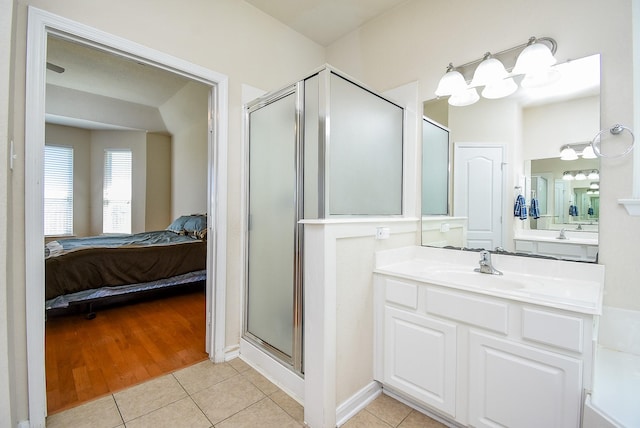 full bathroom featuring a stall shower, tile patterned flooring, connected bathroom, and vanity