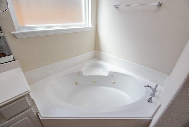 full bath with vanity and a whirlpool tub