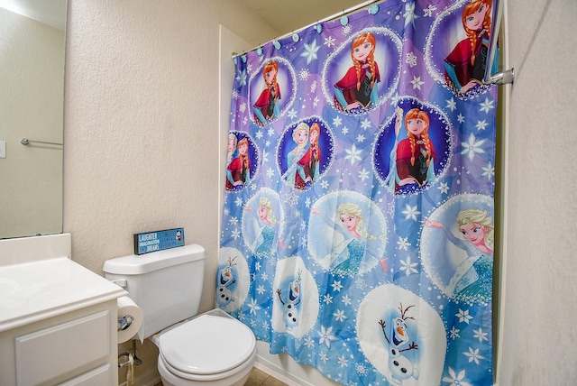 full bathroom featuring toilet, a textured wall, curtained shower, and vanity