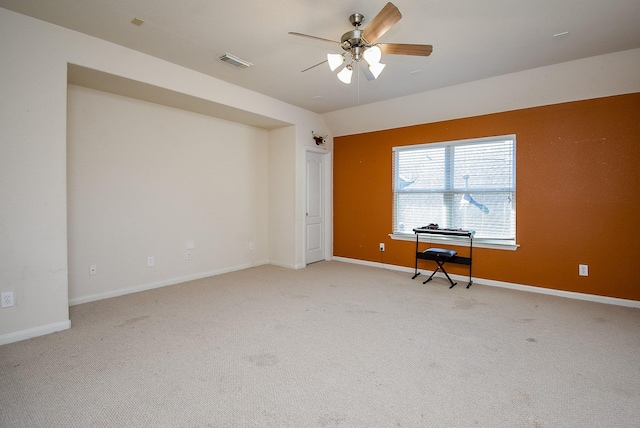 unfurnished office with a ceiling fan, light colored carpet, visible vents, and baseboards