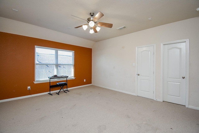 unfurnished bedroom with baseboards, visible vents, vaulted ceiling, and light colored carpet