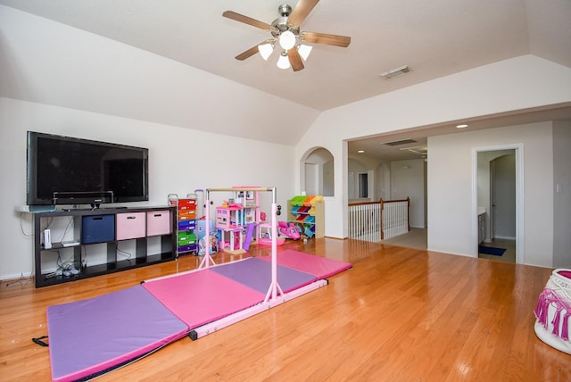 playroom featuring a ceiling fan, visible vents, vaulted ceiling, and wood finished floors