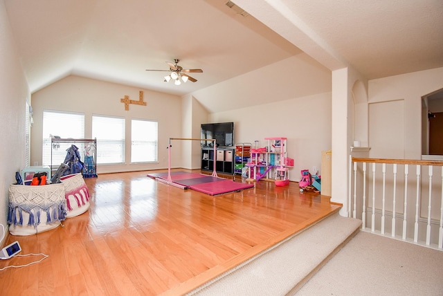 rec room featuring a ceiling fan, visible vents, vaulted ceiling, and wood finished floors