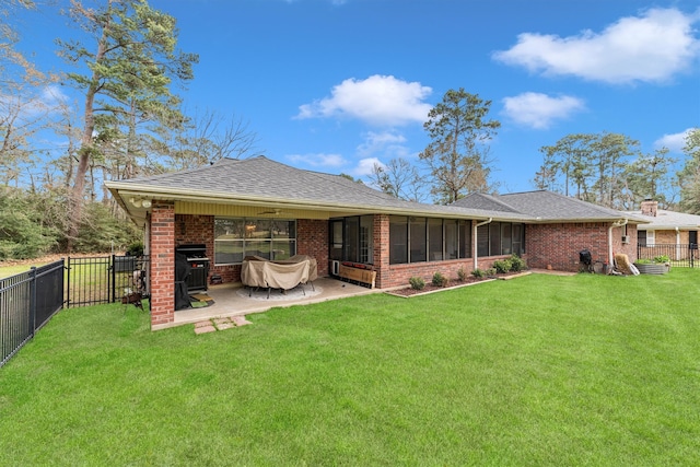 rear view of property featuring a fenced backyard, a lawn, and brick siding