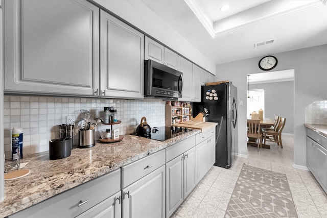 kitchen with appliances with stainless steel finishes, backsplash, gray cabinets, and visible vents