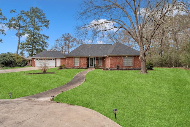 single story home featuring driveway, brick siding, a shingled roof, an attached garage, and a front yard