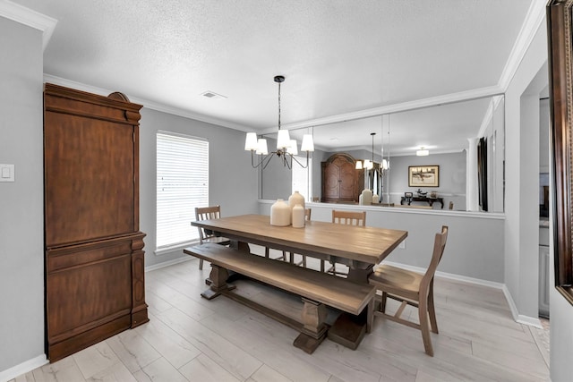 dining room with crown molding, a notable chandelier, visible vents, a textured ceiling, and baseboards