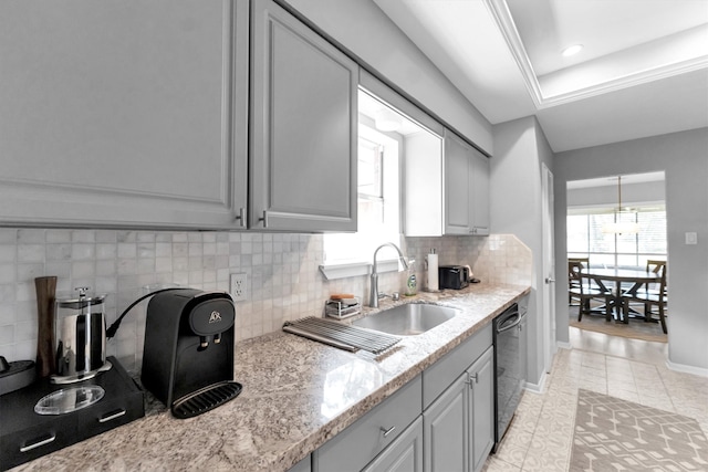 kitchen featuring dishwasher, a sink, a wealth of natural light, and baseboards