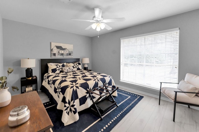 bedroom with wood finished floors, a ceiling fan, and baseboards