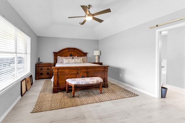 bedroom with a barn door, baseboards, a ceiling fan, lofted ceiling, and light wood-style floors