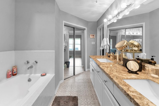 bathroom with a garden tub, double vanity, tile patterned flooring, and a sink