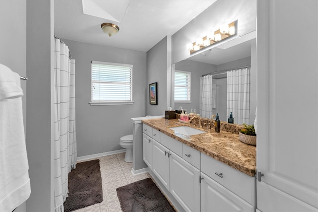 bathroom featuring toilet, vanity, and baseboards