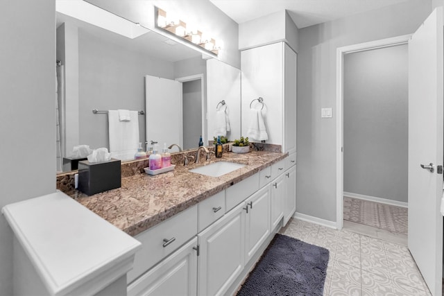 bathroom featuring tile patterned flooring, vanity, and baseboards